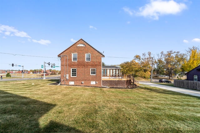 view of side of home featuring a yard and a deck