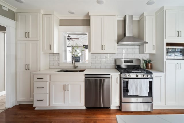 kitchen with wall chimney exhaust hood, white cabinetry, and appliances with stainless steel finishes