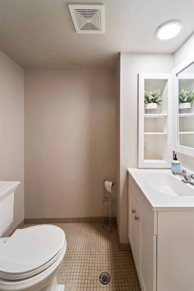 bathroom with tile patterned flooring, vanity, and toilet