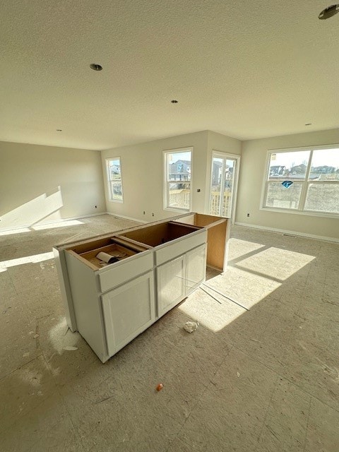 kitchen featuring white cabinetry, a kitchen island, and a textured ceiling