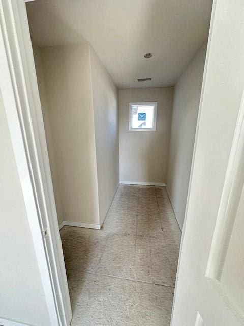 hallway with visible vents and baseboards