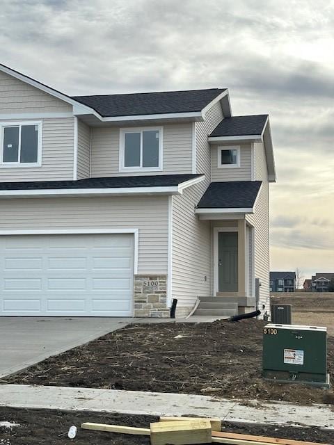 view of property featuring concrete driveway and an attached garage