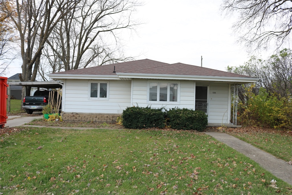 view of front of home with a carport and a front lawn