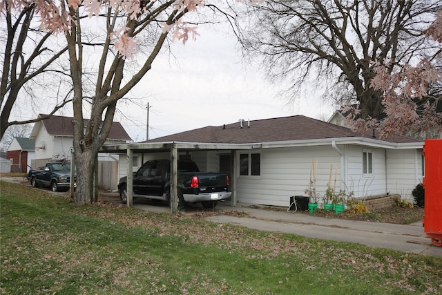 rear view of house featuring a yard and a carport