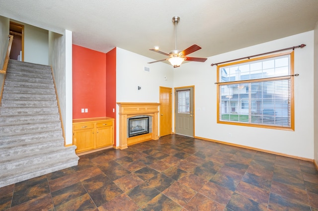 unfurnished living room featuring a textured ceiling and ceiling fan