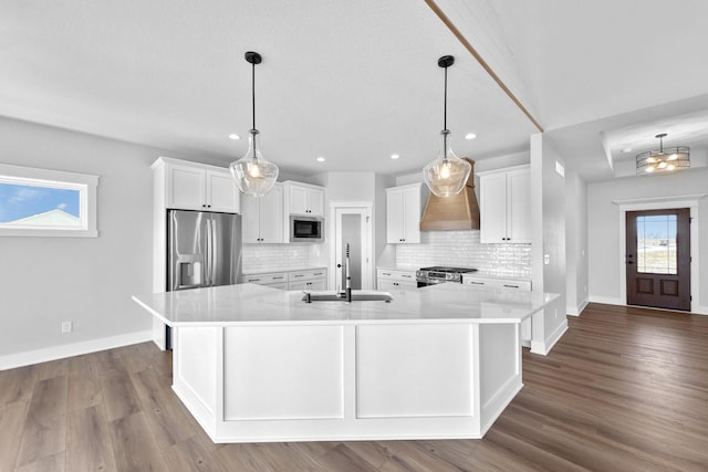 kitchen featuring a large island, pendant lighting, sink, white cabinetry, and stainless steel appliances