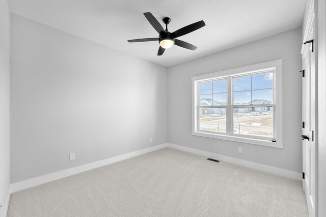 empty room featuring light colored carpet and ceiling fan