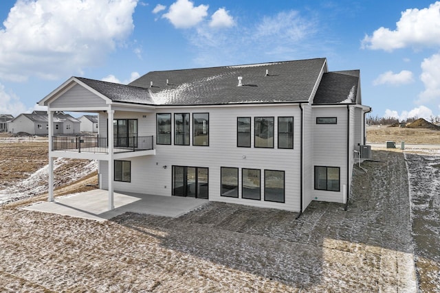 back of house featuring cooling unit, a balcony, and a patio area