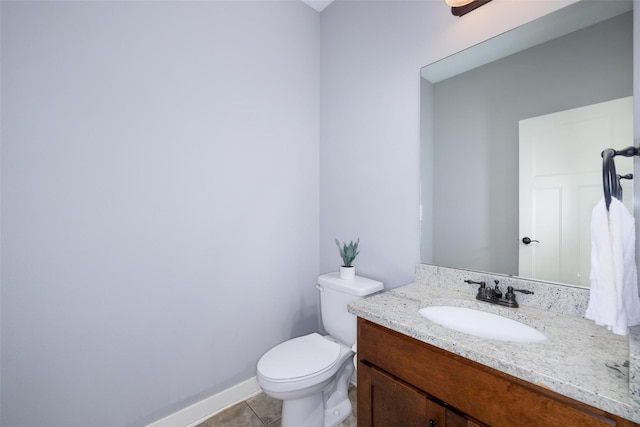 half bathroom featuring vanity, tile patterned floors, toilet, and baseboards