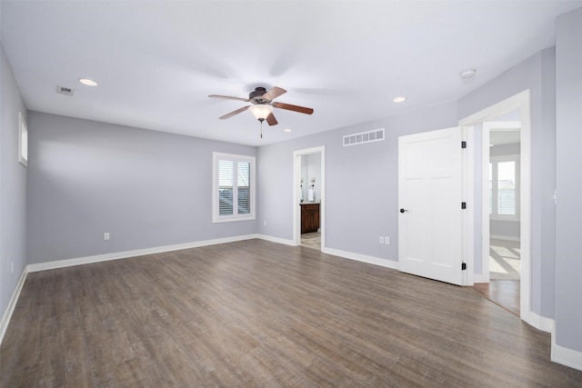 interior space with visible vents, a ceiling fan, baseboards, and dark wood-style flooring