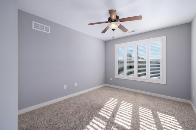 empty room with visible vents, carpet flooring, baseboards, and ceiling fan