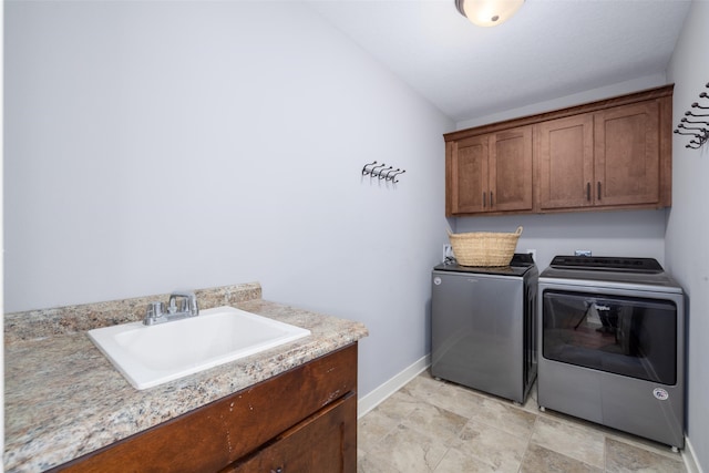 laundry room featuring cabinet space, washer and dryer, baseboards, and a sink