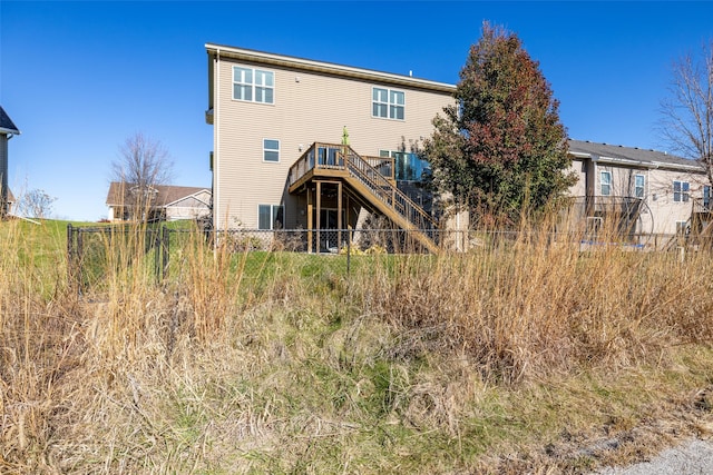 back of house with stairway, a deck, and fence