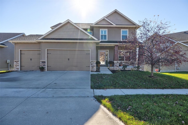 craftsman inspired home featuring stone siding, driveway, a front lawn, and an attached garage