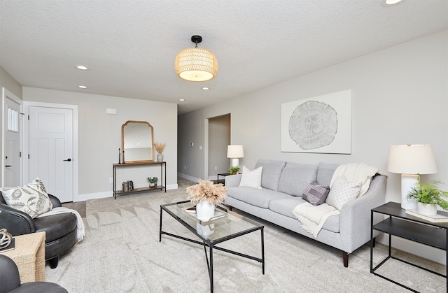 living room with a textured ceiling and light carpet