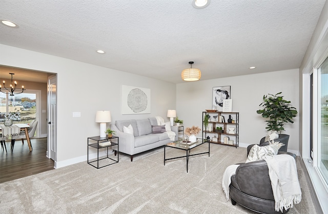 living room featuring wood-type flooring, a textured ceiling, and a notable chandelier