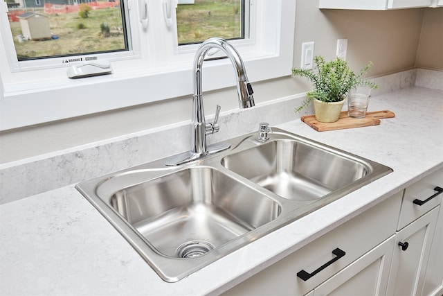 room details featuring sink and white cabinets