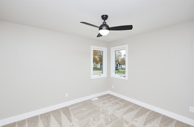 carpeted spare room with ceiling fan and a textured ceiling