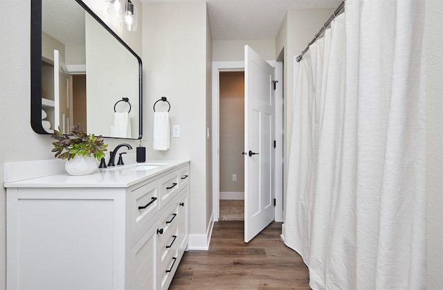 bathroom with vanity, a textured ceiling, and hardwood / wood-style flooring