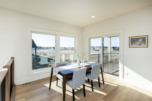 dining space with light wood-style flooring, recessed lighting, visible vents, and baseboards