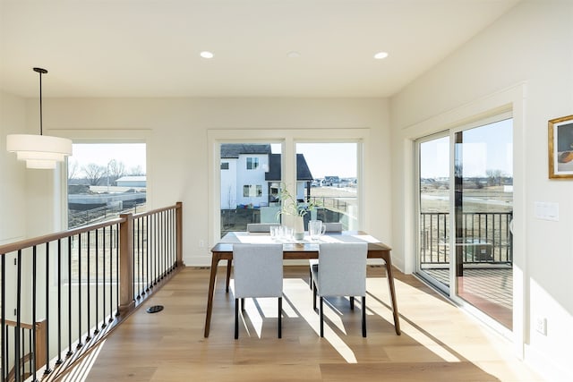 dining space featuring light hardwood / wood-style flooring and a water view