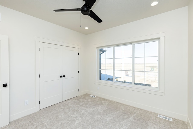 unfurnished bedroom featuring carpet, visible vents, and baseboards