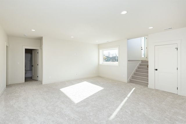 unfurnished room with visible vents, baseboards, light colored carpet, stairs, and recessed lighting