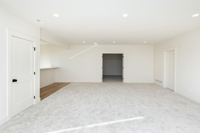 carpeted empty room featuring baseboards, visible vents, and recessed lighting