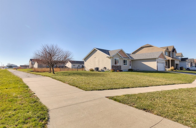 view of front of house featuring central AC unit, a garage, and a front lawn