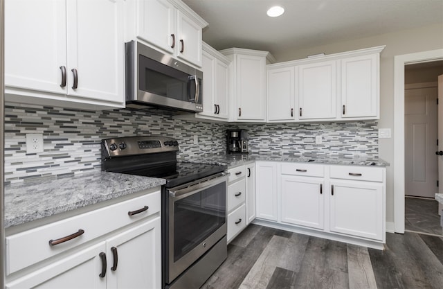 kitchen featuring dark hardwood / wood-style flooring, white cabinetry, backsplash, and appliances with stainless steel finishes