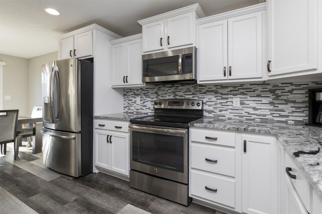 812 SE 15th St, Grimes, IA 50111 - kitchen with stainless steel appliances, dark wood-type flooring, white cabinets, tasteful backsplash, and recessed lighting