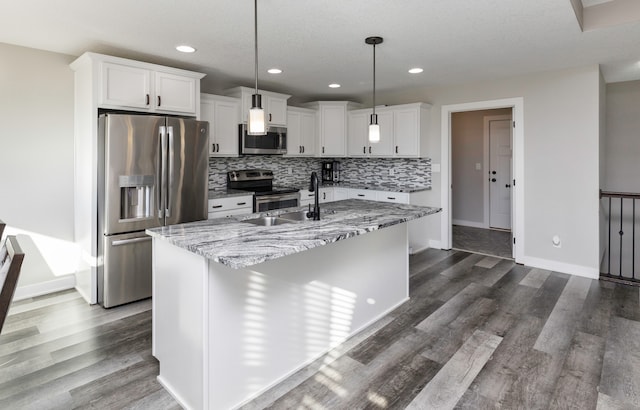 kitchen featuring hanging light fixtures, dark hardwood / wood-style floors, an island with sink, white cabinets, and appliances with stainless steel finishes