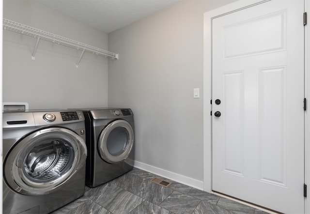 laundry area with a textured ceiling and washing machine and clothes dryer