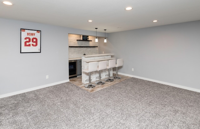 interior space with light carpet, beverage cooler, and indoor bar