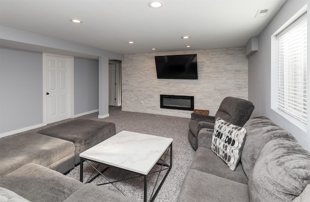 living room featuring carpet flooring and a stone fireplace