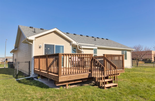 rear view of property featuring a lawn and a deck