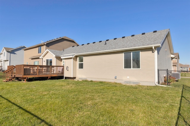 rear view of house with a lawn, a wooden deck, and central AC