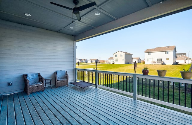 wooden deck featuring ceiling fan and a yard