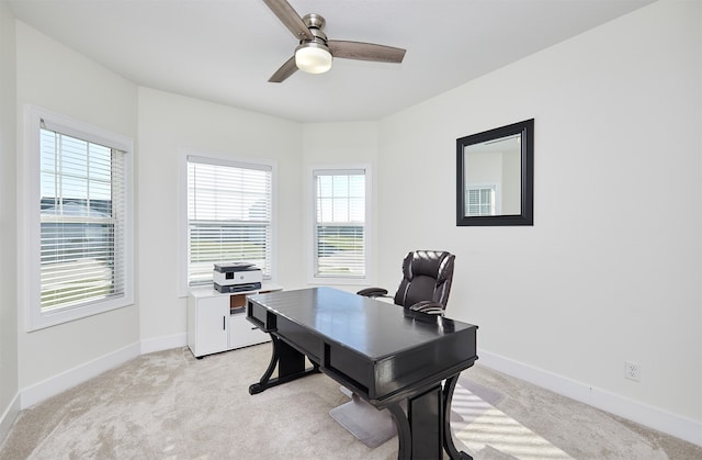 carpeted office space with ceiling fan and a healthy amount of sunlight