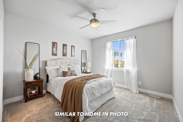 bedroom featuring a ceiling fan, baseboards, a textured ceiling, and carpet flooring