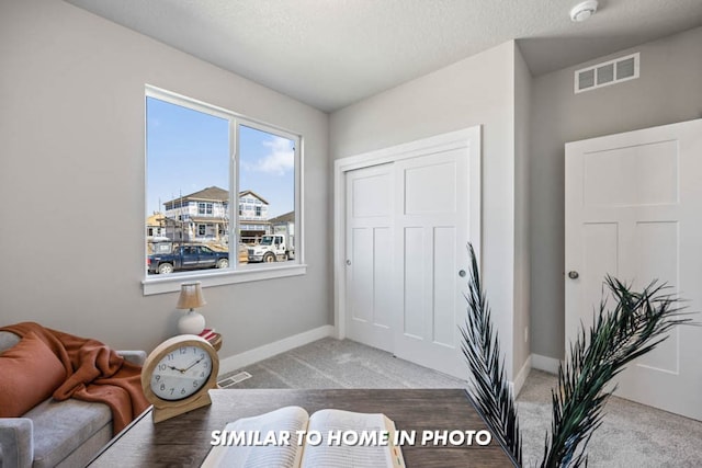 living area featuring visible vents, baseboards, and carpet floors