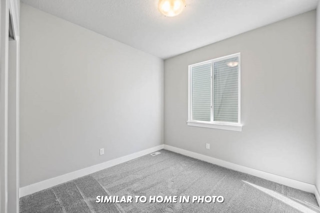 empty room featuring baseboards and carpet