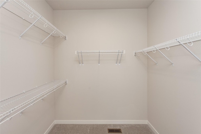 walk in closet featuring visible vents and light colored carpet