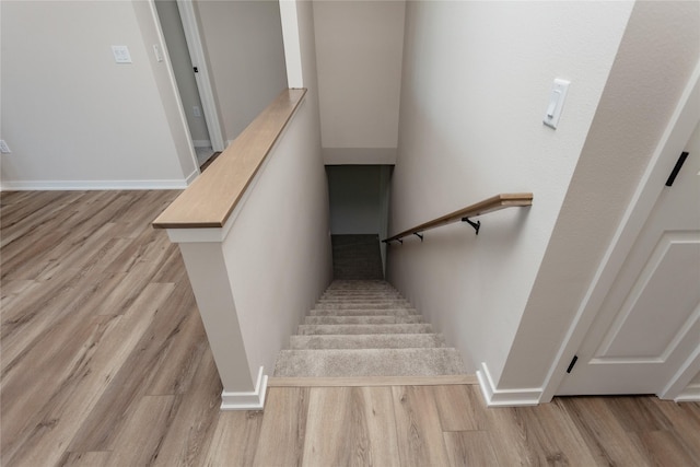 stairs with baseboards and wood finished floors