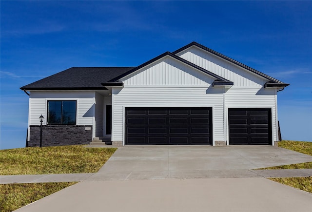 modern inspired farmhouse with concrete driveway, a garage, and a shingled roof