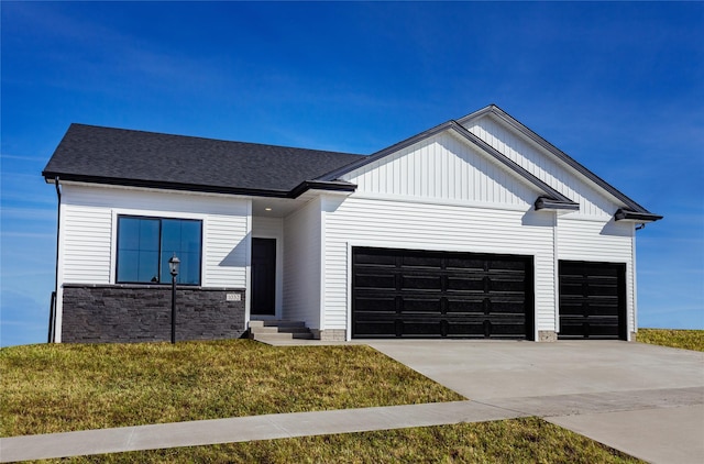 modern inspired farmhouse with a front lawn, driveway, entry steps, roof with shingles, and a garage