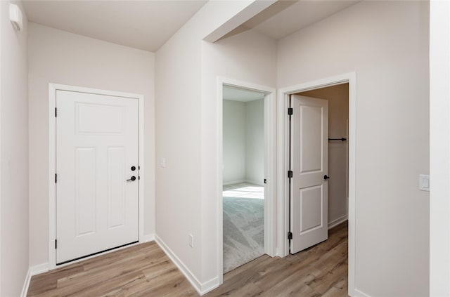 foyer featuring light wood-style flooring and baseboards