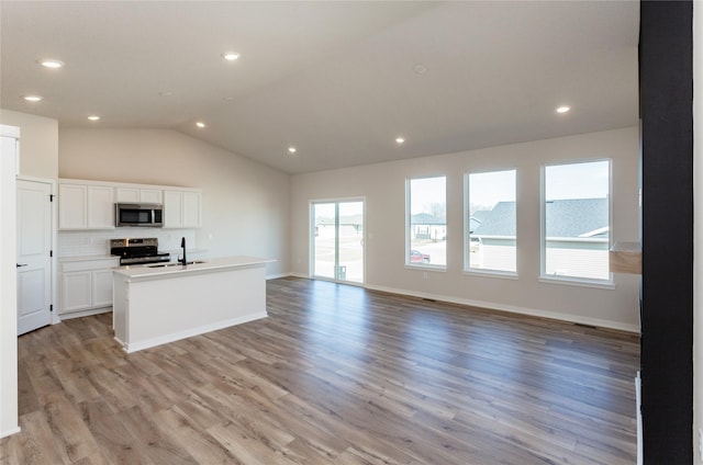 kitchen with light wood-style flooring, white cabinets, a wealth of natural light, and stainless steel appliances