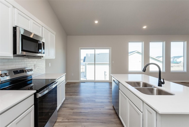 kitchen with recessed lighting, a sink, decorative backsplash, stainless steel appliances, and light wood-type flooring