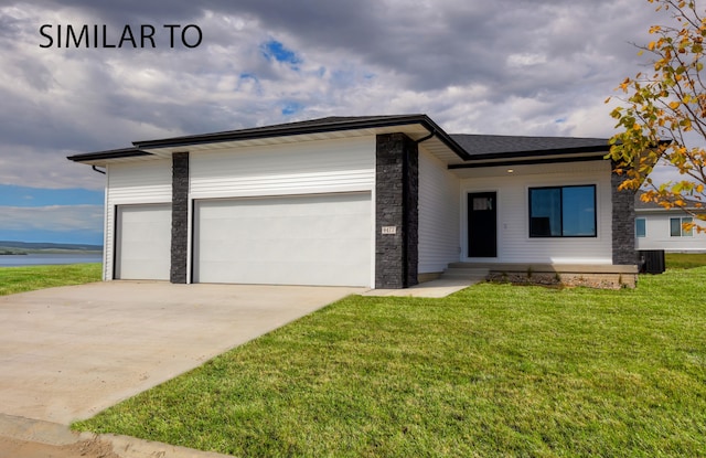 view of front facade featuring cooling unit, a garage, and a front yard